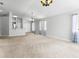 Open concept living room with neutral carpet, updated light fixtures, and ample natural light at 25830 Crippen Dr, Land O Lakes, FL 34639