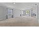 Spacious living room with neutral colored carpet, modern design, and sliding glass door to the back patio at 25830 Crippen Dr, Land O Lakes, FL 34639