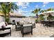 Outdoor patio with dining and lounge area, surrounded by lush greenery and a white fence at 25830 Crippen Dr, Land O Lakes, FL 34639