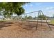 View of a community playground featuring swingsets and a playground surrounded by mature shade trees at 25830 Crippen Dr, Land O Lakes, FL 34639
