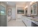 Bright bathroom features double vanity with marble counters, tub, and glass-enclosed shower at 20 Outlook Way Blvd # 7, Dunedin, FL 34698