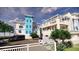 Exterior elevation of multi-level townhomes with car parking and community landscaping at 265 Causeway Blvd # 7, Dunedin, FL 34698