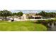 Clubhouse exterior view with well-manicured lawn, a parking lot, palm trees, and outdoor seating at 2700 Cove Cay Dr # 2B, Clearwater, FL 33760