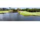 Scenic golf course view with lush green fairways, a wooden bridge over a pond, and palm trees at 2700 Cove Cay Dr # 2B, Clearwater, FL 33760