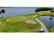 Aerial view of a golf course with sand traps, a green, golfers, and a water hazard at 2700 Cove Cay Dr # 2B, Clearwater, FL 33760