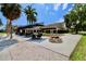 Outdoor patio area with tables, chairs, umbrellas, string lights, and clubhouse in the background at 2700 Cove Cay Dr # 2B, Clearwater, FL 33760