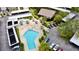 Aerial view of a community pool, lounge chairs, tropical umbrellas, and lush greenery at 2700 Cove Cay Dr # 2B, Clearwater, FL 33760