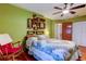 Bedroom with a quilt-covered bed, wood floors, light-green walls, and decorative wall shelves at 2800 54Th N St, St Petersburg, FL 33710