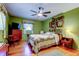 Comfortable bedroom with a ceiling fan, wood floors, and decoratively painted green walls at 2800 54Th N St, St Petersburg, FL 33710