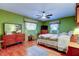 Bright bedroom with green walls, wood floors, and ceiling fan with windows that let in natural light at 2800 54Th N St, St Petersburg, FL 33710