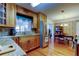 Well-lit kitchen with wood cabinets, granite counters, stainless fridge, and views into the dining and living areas at 2800 54Th N St, St Petersburg, FL 33710