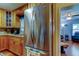 Stainless steel refrigerator complements this kitchen's wood cabinets and connects to a bright living space at 2800 54Th N St, St Petersburg, FL 33710