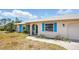 Charming single-story home with bright blue shutters, lush greenery, and well-maintained lawn at 2810 9Th St, Englewood, FL 34224