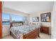 Cozy bedroom with a floral-patterned bedspread, large windows offering stunning views of the bay, and a wicker bed frame at 31 Island Way # 1507, Clearwater Beach, FL 33767
