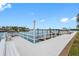 Picturesque waterfront dock with white railings, benches and serene water views under a partly cloudy sky at 31 Island Way # 1507, Clearwater Beach, FL 33767