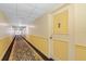 Long condo hallway with neutral walls and patterned carpet leading to the residence's front door at 31 Island Way # 1507, Clearwater Beach, FL 33767