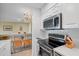 Modern kitchen with white cabinetry, stainless steel appliances, and views into the dining area at 31 Island Way # 1507, Clearwater Beach, FL 33767