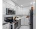 Modern kitchen featuring stainless appliances, white cabinets and countertops, and tiled flooring at 31 Island Way # 1507, Clearwater Beach, FL 33767