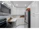 Modern kitchen featuring stainless appliances, white cabinets and countertops, and tiled flooring at 31 Island Way # 1507, Clearwater Beach, FL 33767
