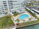 A kidney bean shaped pool surrounded by palm trees and lounge chairs with an adjoining building at 31 Island Way # 1507, Clearwater Beach, FL 33767