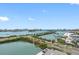 Stunning waterfront view showcasing buildings, a marina, and a coastal road under a clear blue sky with scattered clouds at 31 Island Way # 1507, Clearwater Beach, FL 33767