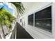 Exterior building hallway showing unit 208, dark gray flooring, white railings and walls, and mature palm trees at 3128 59Th S St # 206, Gulfport, FL 33707