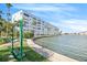 Stunning waterfront view of the condominium complex featuring lush landscaping and seating at 3128 59Th S St # 206, Gulfport, FL 33707