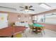 Well-lit game room with ceiling fan, cabinets, and two tables for social gatherings and entertainment at 3128 59Th S St # 206, Gulfport, FL 33707