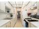 Galley kitchen features white cabinets and appliances with an open view into the living area at 3128 59Th S St # 206, Gulfport, FL 33707