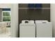 Bright laundry room with shelving, full-size washer and dryer, and decorative storage baskets at 31781 Griffin Sands Ln, San Antonio, FL 33576