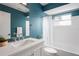 Well-lit bathroom features a vanity, large mirror and shower with curtain at 3353 Montano Ave, Spring Hill, FL 34609