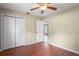 Simple bedroom with a ceiling fan, closet and doorway to another room at 3353 Montano Ave, Spring Hill, FL 34609