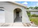 Charming home entrance with a gray front door, unique archway, and well-maintained landscaping at 3353 Montano Ave, Spring Hill, FL 34609