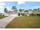 Inviting single-story home with an attached garage, neutral exterior, and green front lawn at 3353 Montano Ave, Spring Hill, FL 34609