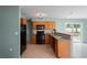 Cozy kitchen features wood cabinets, black appliances, and tile floors, offering a functional and inviting space at 3353 Montano Ave, Spring Hill, FL 34609