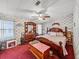 Cozy bedroom with wood furnishings, floral wallpaper, and a ceiling fan at 35051 Colony Hills Dr, Zephyrhills, FL 33541