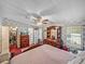 Bedroom with floral wallpaper, ceiling fan, dressers, and closet access at 35051 Colony Hills Dr, Zephyrhills, FL 33541