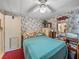 Bedroom featuring a bed, ceiling fan, floral wallpaper, and a side table at 35051 Colony Hills Dr, Zephyrhills, FL 33541