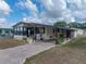 Single-story home boasts covered parking, a welcoming entryway, and beautiful landscaping at 35051 Colony Hills Dr, Zephyrhills, FL 33541