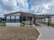 Single-story home boasts covered parking, a welcoming entryway, and beautiful landscaping at 35051 Colony Hills Dr, Zephyrhills, FL 33541