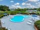 Overhead view of an outdoor swimming pool with surrounding lounge chairs and manicured landscaping at 35051 Colony Hills Dr, Zephyrhills, FL 33541