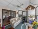 Spacious sunroom featuring a floral sofa, ceiling fan, and multiple windows for natural light at 35051 Colony Hills Dr, Zephyrhills, FL 33541