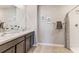 This bathroom features a double sink vanity, and a tiled shower with glass door at 36093 Sunflower Hill Dr, Zephyrhills, FL 33541