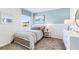 Cozy bedroom with blue accent wall, patterned bedding, and a sun-filled window at 36201 Sunflower Hill Dr, Zephyrhills, FL 33541