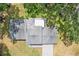 Aerial view showcasing the roof, driveway, and surrounding yard of the house, nestled among mature trees at 403 Westbrook Ave, Brandon, FL 33511