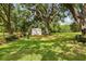 Backyard featuring grass, shade tree, shed, and decorative yard ornament at 403 Westbrook Ave, Brandon, FL 33511