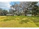 A sprawling backyard with mature trees, a white shed and a beautiful lawn at 403 Westbrook Ave, Brandon, FL 33511