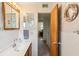 Bathroom with a wooden vanity, tiled walls, and a decorative seashell mirror at 403 Westbrook Ave, Brandon, FL 33511