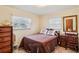 Cozy bedroom with a comfortable bed, dresser, and windows with lace curtains at 403 Westbrook Ave, Brandon, FL 33511