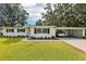 Front view of home with a well-manicured lawn, a carport, and lush landscaping, creating a welcoming curb appeal at 403 Westbrook Ave, Brandon, FL 33511